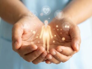 Beschermende handen omvatten gloeiende menselijke silhouet met medische preventiepictogrammen op blauwe achtergrond