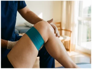 Fysiotherapeut begeleidt knierevalidatie-oefening met weerstandsband in medische kliniek